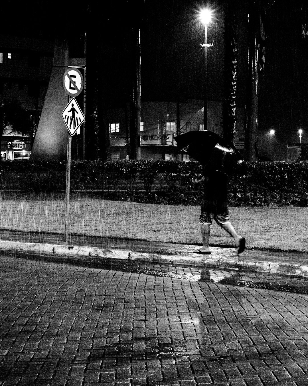 Rainy city street at night with reflections on wet pavement